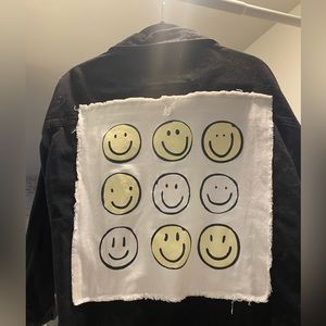 Black oversized denim jacket with smiley faces on back